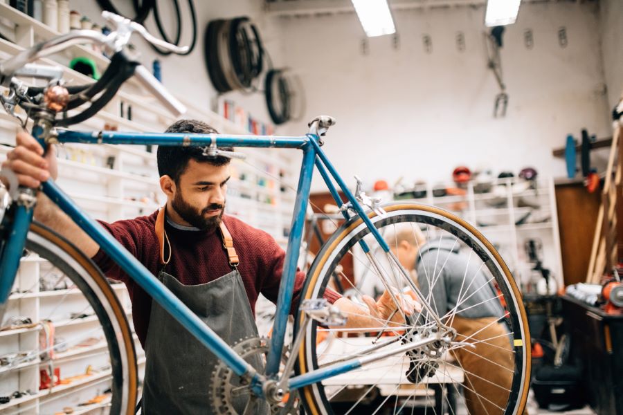 man works on bicycle in shop