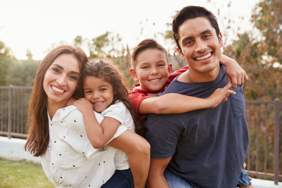 a young Hispanic family smiles at the camera