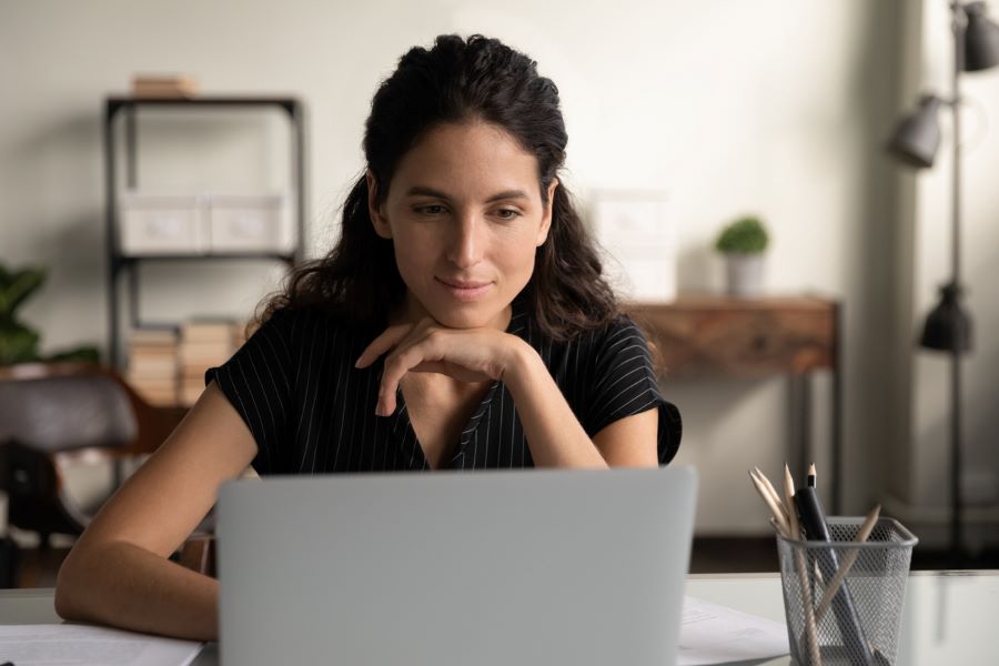 a young woman looking at her laptop screen