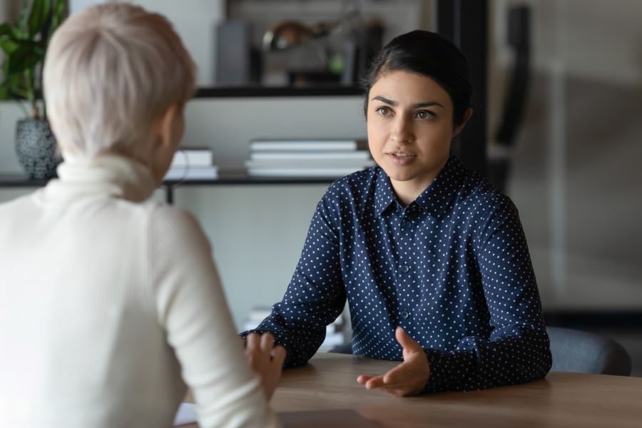 Indian woman and Caucasian woman talking during meeting