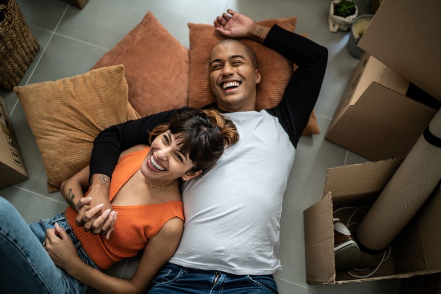 Happy young couple lying on the floor on pillows