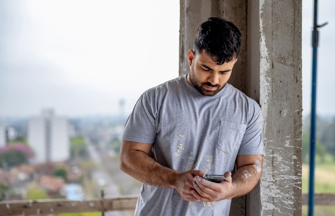 Construction worker using a cell phone at a building site