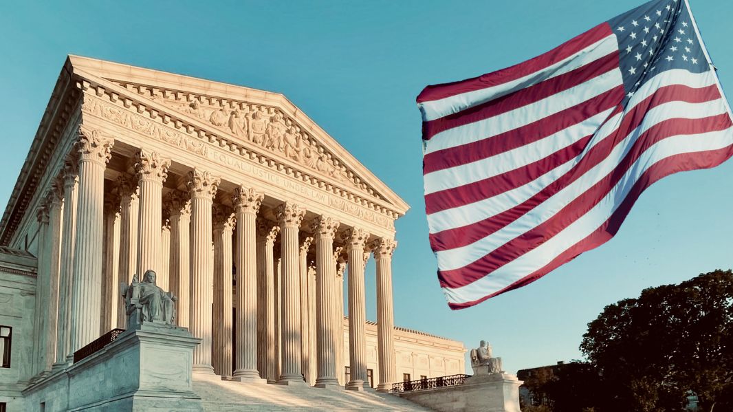 in the background is a courthouse with a waving American flag in the foreground